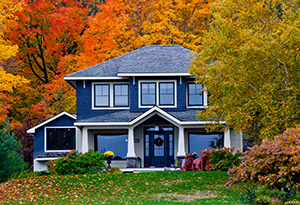 A cozy house surrounded by colorful fall foliage, with a well-maintained lawn and trees displaying autumn leaves A cozy house surrounded by colorful fall foliage, with a well-maintained lawn and trees displaying autumn leaves