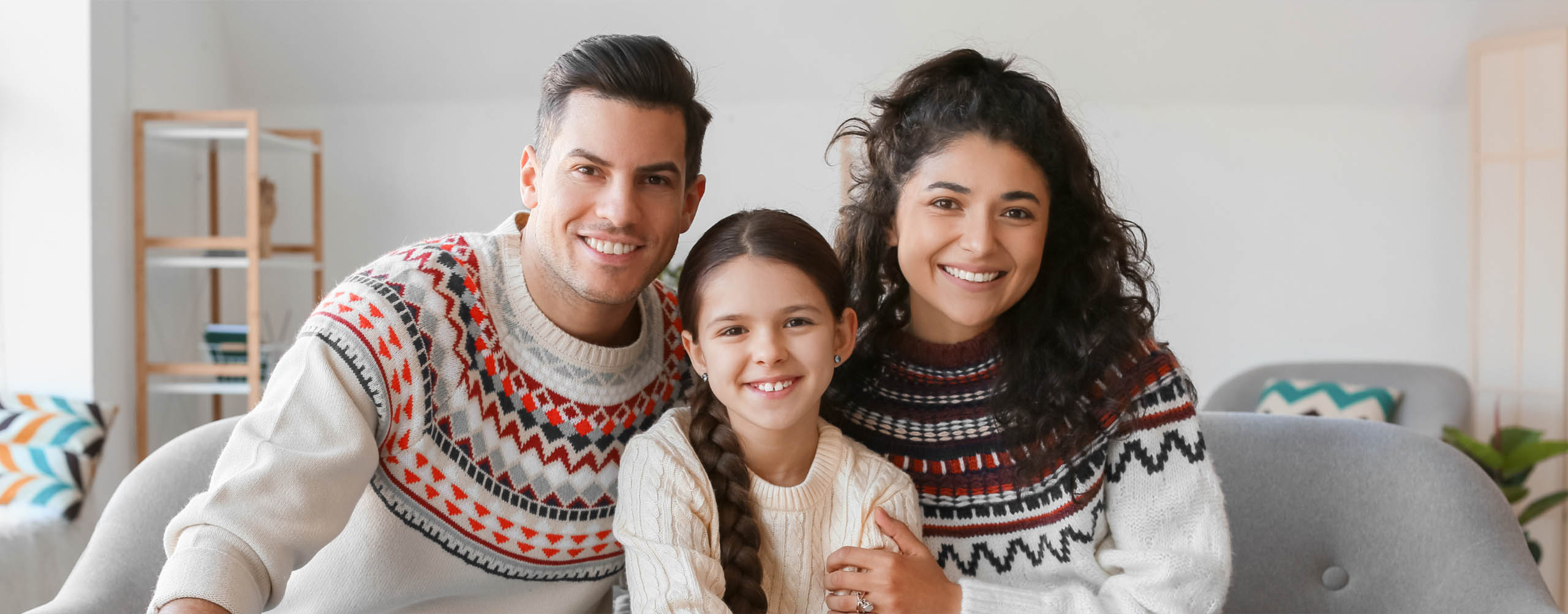 Happy family wearing matching winter-themed sweaters