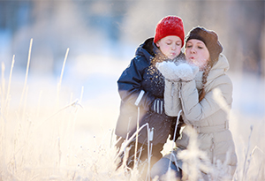 Life Insurance - Winter Box Mother and child blowing snow on mother's hand
